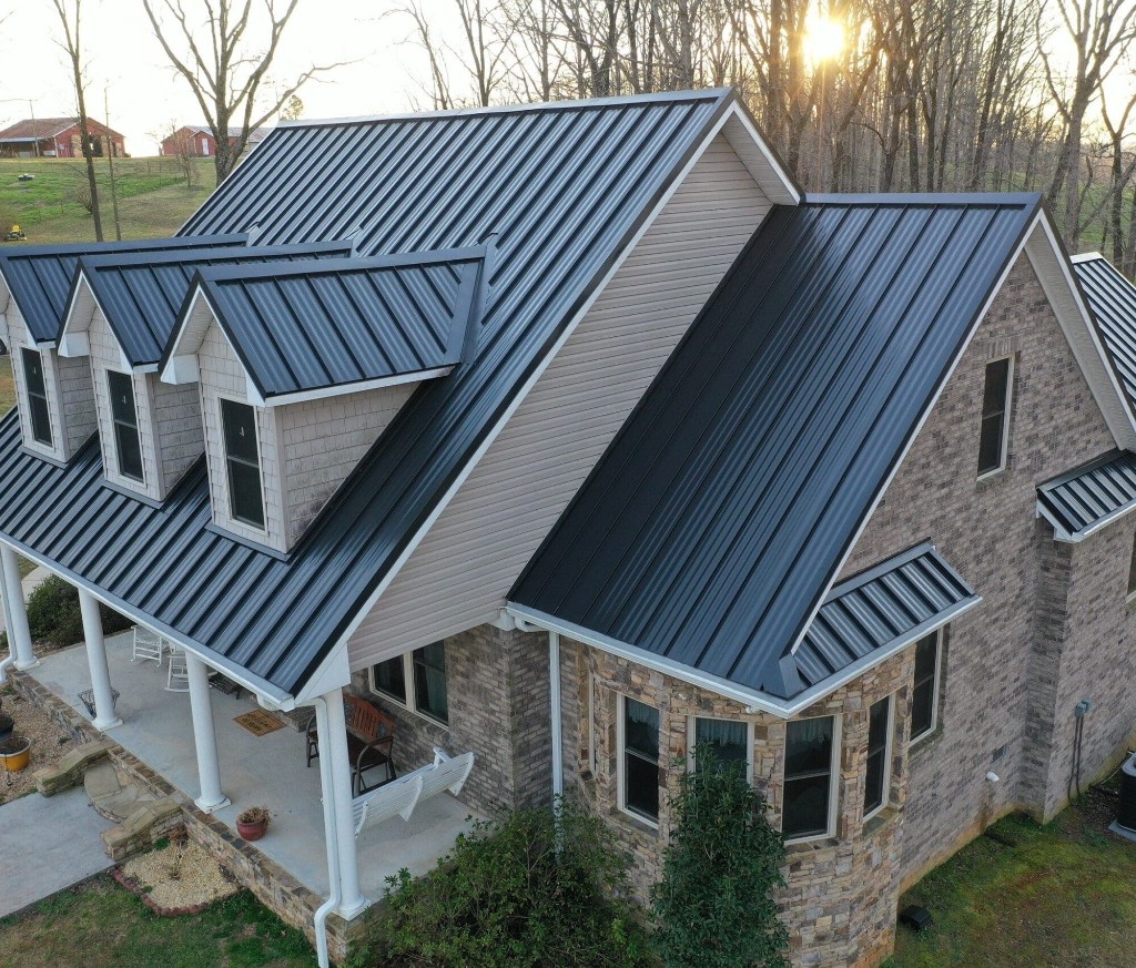A completed dark standing seam metal roof on a large two-story home.