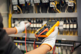 Electrician testing wiring in an electrical control panel