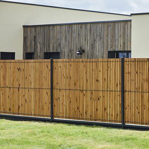 Modern wooden slat fence installed in front of a home