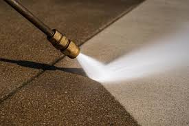 Pressure washer cleaning a concrete driveway